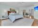 Serene bedroom featuring a king-sized bed and hardwood floors with access to the ensuite bathroom at 4051 Colonel Vanderhorst Cir, Mount Pleasant, SC 29466