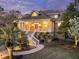 Lovely home with a charming front porch, detailed white railings, and mature landscaping at dusk at 4051 Colonel Vanderhorst Cir, Mount Pleasant, SC 29466