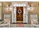 Charming front door with sidelights, adorned with a decorative wreath and flanked by rocking chairs at 4051 Colonel Vanderhorst Cir, Mount Pleasant, SC 29466