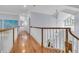 Second floor hallway with gleaming hardwood floors and a white banister overlooking the entrance foyer at 4051 Colonel Vanderhorst Cir, Mount Pleasant, SC 29466