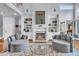 Bright living room with a fireplace, built-in bookshelves, hardwood floors, and round chairs at 4051 Colonel Vanderhorst Cir, Mount Pleasant, SC 29466