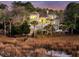 Beautiful exterior view of the house surrounded by palm trees and tall marsh grass near the water at 4051 Colonel Vanderhorst Cir, Mount Pleasant, SC 29466
