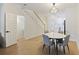 Dining area adjacent to the kitchen, stairs and powder room with a modern light fixture at 4789 Arco Ln, North Charleston, SC 29418