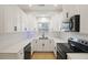 Contemporary kitchen featuring white cabinetry, subway tile, quartz countertops, and black appliances at 4789 Arco Ln, North Charleston, SC 29418