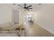 Open-concept living area with a ceiling fan, gray sofa, dining area, and hardwood floors at 4789 Arco Ln, North Charleston, SC 29418