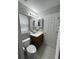 Cozy bathroom featuring a single sink vanity, matching mirror cabinet, and a window with blinds at 4957 Trump St, North Charleston, SC 29420
