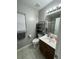 Well-lit bathroom with a single sink vanity, open shelving, and a window with blinds at 4957 Trump St, North Charleston, SC 29420