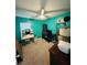 Bright bedroom with a turquoise accent wall, ceiling fan, and a window with blinds offering natural light at 4957 Trump St, North Charleston, SC 29420