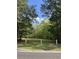 Large grassy lot with a perimeter wire supported by wooden posts, shaded by mature trees at 4957 Trump St, North Charleston, SC 29420