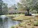 Scenic pond view with a fountain, surrounded by lush greenery and a nearby gazebo and playground at 4957 Trump St, North Charleston, SC 29420