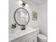 Cozy half-bath featuring a modern round mirror, beadboard vanity, and a minimalist design with artful accents at 5330 Waterview Dr, North Charleston, SC 29418