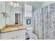 Bathroom with granite countertop, mirror, and a blue patterned shower curtain at 5409 Clairmont Ln, North Charleston, SC 29420