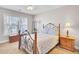 Charming bedroom featuring a wrought iron bed frame, light-filled window, and a ceiling fan at 5409 Clairmont Ln, North Charleston, SC 29420