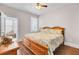 Bedroom featuring a ceiling fan, a wooden bed frame, and hardwood floors, leading to a sunroom at 5409 Clairmont Ln, North Charleston, SC 29420