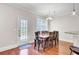 Bright dining area with hardwood floors, a table with 8 chairs, and a door to the outside at 5409 Clairmont Ln, North Charleston, SC 29420