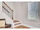 Stairway with hardwood steps, white risers, and an iron railing near a leather chair at 5409 Clairmont Ln, North Charleston, SC 29420