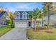 Charming two-story home with a well-manicured lawn and a palm tree in the front yard at 5415 Clairmont Ln, North Charleston, SC 29420