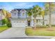 Charming two-story home with a light blue facade, manicured lawn, and mature palm tree at 5415 Clairmont Ln, North Charleston, SC 29420