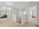 Upstairs hallway with neutral carpet, walls, and trim leads to cozy bedrooms, promoting relaxation at 5415 Clairmont Ln, North Charleston, SC 29420