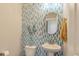 Half bath featuring modern pedestal sink, oval mirror, and unique wallpaper at 543 Pendleton Dr, Moncks Corner, SC 29461