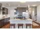 Well-lit kitchen with stainless appliances, dark cabinets, large island with barstool seating, and hardwood floors at 543 Pendleton Dr, Moncks Corner, SC 29461
