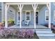 Inviting covered porch with seating, beautiful plantings and stylish decorations at 565 Blueway Ave, Summerville, SC 29486