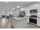 Open-concept kitchen with white cabinets, stainless steel appliances, and a center island overlooking the dining area at 565 Blueway Ave, Summerville, SC 29486
