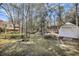 A backyard with mature trees, a storage building, and a well-kept lawn at 5921 Oak St, Hanahan, SC 29410