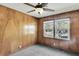 Bedroom featuring wood paneling, ceiling fan, and a large window at 5921 Oak St, Hanahan, SC 29410