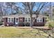 Charming brick home featuring a well-maintained lawn, classic design, and a welcoming entrance with detailed door accents at 5921 Oak St, Hanahan, SC 29410