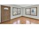 Bright living room featuring hardwood floors, a decorative front door, and updated trim at 5921 Oak St, Hanahan, SC 29410