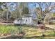 A detached white outbuilding nestled in nature with lush landscaping and architectural details at 5921 Oak St, Hanahan, SC 29410