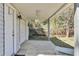 Covered patio featuring exterior entrance, garage, and partial view of a wooded backyard at 5921 Oak St, Hanahan, SC 29410