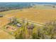 Aerial view features a sprawling landscape of homes, fields, and verdant trees under a blue sky at 729 2Nd Bend Rd, Harleyville, SC 29448
