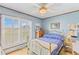 Bright bedroom with a brass bed frame, a white ceiling fan, and large shuttered windows at 729 2Nd Bend Rd, Harleyville, SC 29448