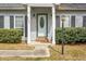 Inviting entryway featuring a classic white door flanked by windows and trimmed shrubbery at 8458 William Moultrie Dr, North Charleston, SC 29420