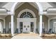 Elegant clubhouse entrance with white columns and rocking chairs, creating an inviting and classic setting at 9021 Delancey Cir, North Charleston, SC 29406