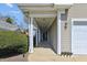Inviting entrance of home featuring covered walkway to front door and attached garage at 9021 Delancey Cir, North Charleston, SC 29406