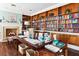 A cozy library with floor-to-ceiling bookshelves and a charming fireplace at 9021 Delancey Cir, North Charleston, SC 29406