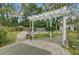 Landscaped backyard with a pergola, stone path, a small sitting area, and partial view of the pool at 958 Mikell Dr, Charleston, SC 29412