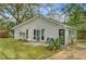 Back exterior of the home with a screened door, open garden area, and lush foliage at 958 Mikell Dr, Charleston, SC 29412