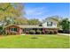 Charming front elevation of a well-maintained home with a lush green lawn, mature trees, and a welcoming entrance at 958 Mikell Dr, Charleston, SC 29412