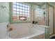 This large bathroom features a large soaking tub and a glass door shower with bright, natural light at 103 Avalon Ct, Goose Creek, SC 29445