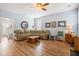 Bright living room featuring an L-shaped sofa, wood-look floors, and a ceiling fan for comfortable living at 103 Avalon Ct, Goose Creek, SC 29445