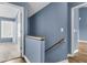 Hallway with a wooden handrail and view into a room with a window, offering good natural lighting at 1127 Tidal View Ln, Charleston, SC 29412