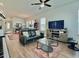 Open-concept living room featuring hardwood floors, TV, and comfortable black leather seating at 114 E Respite Ln, Summerville, SC 29483