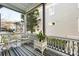 Charming screened-in porch with wicker furniture and a striped rug at 115 Rutledge Ave # A, Charleston, SC 29401
