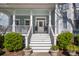 Elegant entryway with white stairs, railings, columns, flowerpots and a light blue covered porch at 122 Lucia St, Charleston, SC 29492