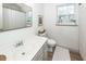Bright bathroom with a single sink vanity, decorative mirror, toilet, and a window for natural light at 122 Moon Shadow Ln, Summerville, SC 29485