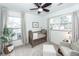 Bedroom showcases a crib, chair, side table, large windows with natural light, and ceiling fan at 122 Moon Shadow Ln, Summerville, SC 29485